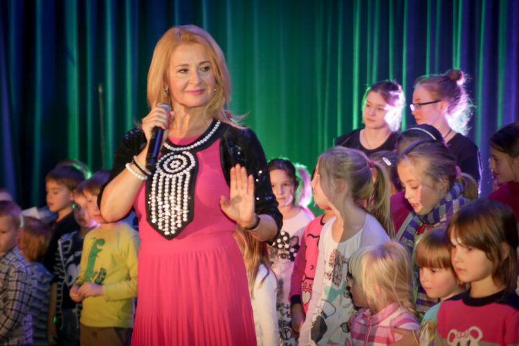 Majka Jeżowska trzyma mikrofon, w tle dzieci